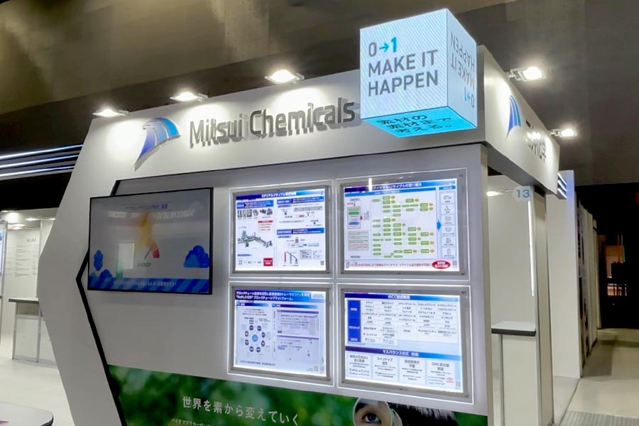 ブース上部、社名横に立方体のビジョンを設置し、横から見ても目立つ看板に