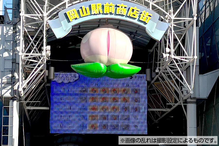 岡山県岡山駅前商店街、有名な桃の看板下で天気予報を映すシースルービジョン
