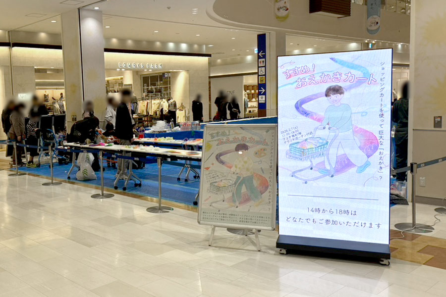 アートイベント「すすめ！おえかきカート」の開催時間などを掲示するパカットビジョン