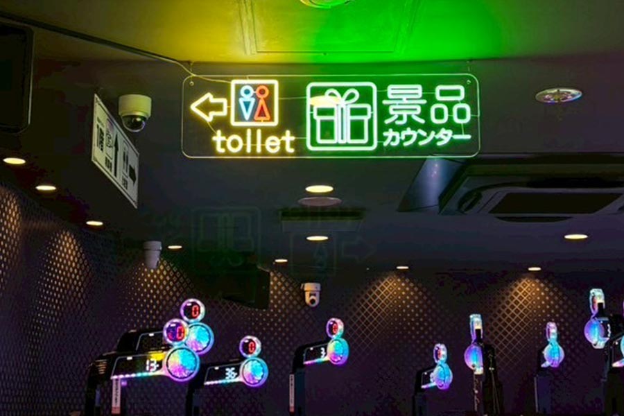 トイレや景品カウンターの案内表示もLEDレインボーネオンで視認性とデザイン性の高い仕上がり