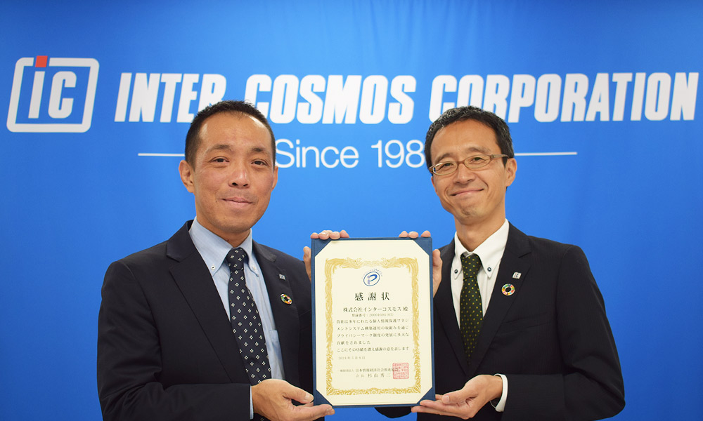 日本情報経済社会推進協会からの感謝状を持つ担当者